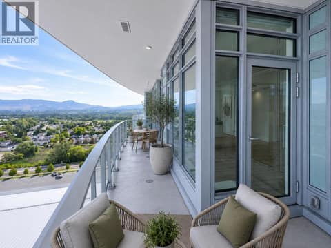 Covered wraparound balcony with multiple seating areas, sweeping mountain views and seamless access from the main living space. *virtually staged at 3699 Capozzi Road Unit# PH6, Lower Mission, Kelowna