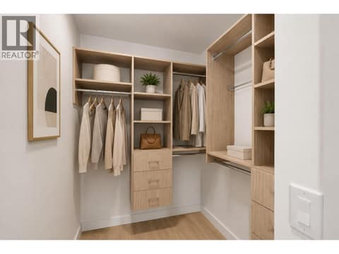 Custom walk-in closet with built-in organizers, drawer storage, hanging space and warm wood finishes for a polished, functional primary suite. *virtually staged at 3699 Capozzi Road Unit# PH6, Lower Mission, Kelowna