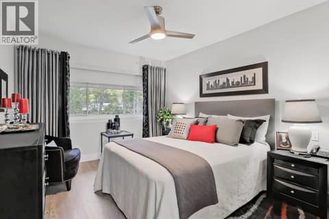 Primary bedroom with ceiling fan and dual room darkening blinds at 3335 Richter Street Unit# 201, Lower Mission, Kelowna