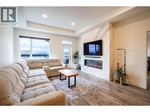Main living room with gorgeous feature fireplace, 9 foot ceilings , laminate floors , bright windows and modern lighting. at 881 Mt.Ida Drive, Middleton Mountain Vernon
