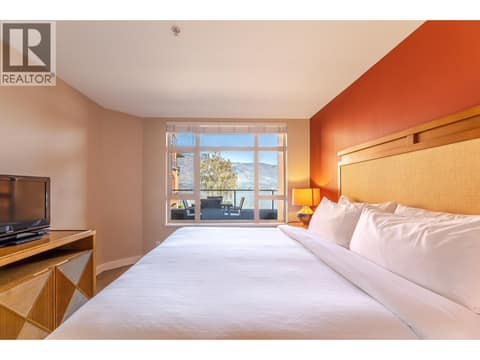 Bedroom with television, window and furnished resort-suite layout. at 15 PARK Place Unit# 209, Osoyoos