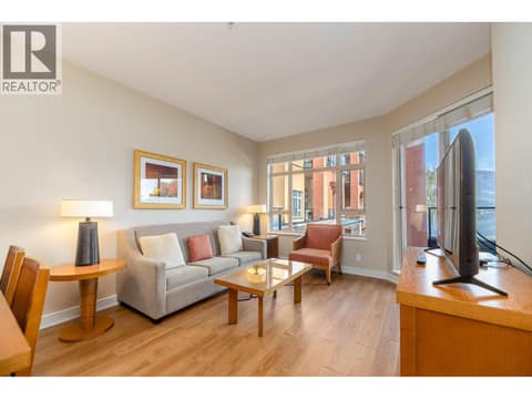 Bright furnished living room with large windows and balcony access. at 15 PARK Place Unit# 209, Osoyoos