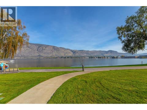 Lakefront walkway with lawn, mature trees and mountain views. at 15 PARK Place Unit# 209, Osoyoos