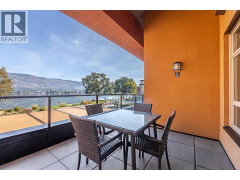 Private covered balcony with outdoor dining space and a lake view. at 15 PARK Place Unit# 209, Osoyoos