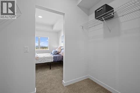 Walk-in Closet in Second Bedroom - Photos are of a similar home; some features may vary at 1057 Frost Road Unit# 110, Upper Mission, Kelowna