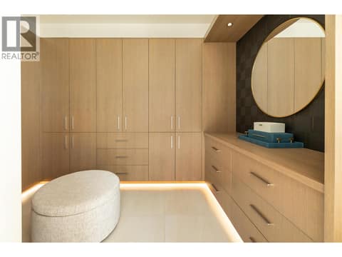 Walk in closet with built in enclosed cabinetry and accent lighting at 538 Clifton Court, Glenmore, Kelowna