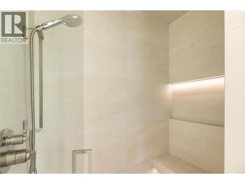 Walk in glass shower with lighting in niche, rain head and slide bar at 538 Clifton Court, Glenmore, Kelowna
