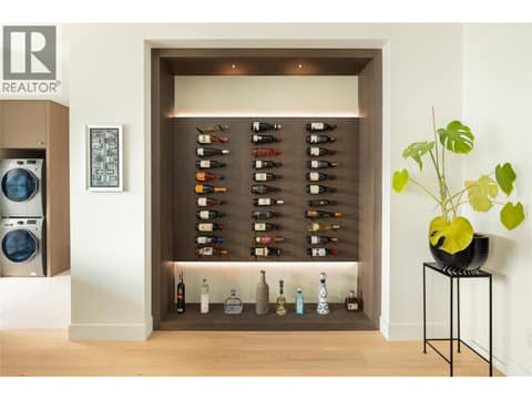 Wine Display Wall with accent lighting and plaster custom finish at 538 Clifton Court, Glenmore, Kelowna