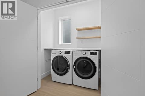 Laundry room off upper primary suite. Photo of opposite side unit at 662 Birch Avenue Unit# 4, Kelowna South