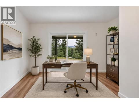 Main floor bedroom virtually staged as home office at 10824 Westshore Road, Okanagan North, Vernon