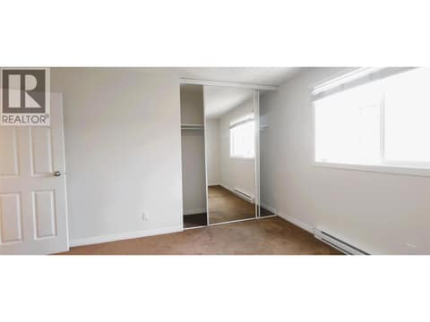 Primary bedroom with mirror closet doors at 625 Rowcliffe Avenue Unit# 207, Kelowna South