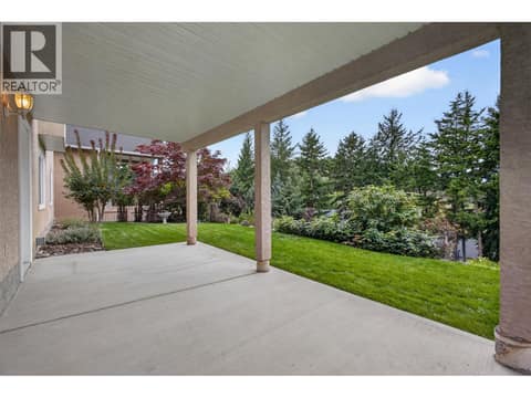 Covered lower patio beneath the deck provides a private, shaded outdoor space to relax and enjoy the backyard. at 330 Woodwind Court, Glenmore, Kelowna