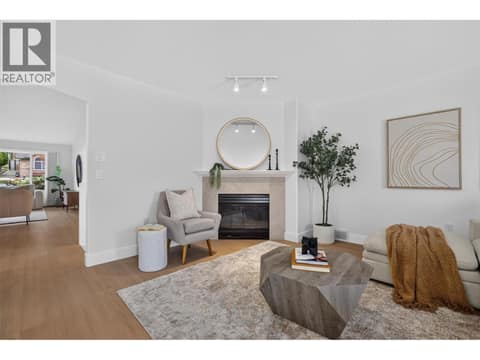 Cozy family room just off the kitchen featuring a gas fireplace, creating a comfortable space to relax while staying connected to the heart of the home. at 330 Woodwind Court, Glenmore, Kelowna