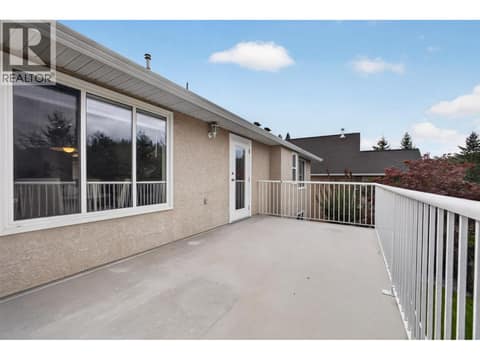 Large deck with beautiful valley and mountain views, offering plenty of space for outdoor dining, entertaining, and relaxing. at 330 Woodwind Court, Glenmore, Kelowna