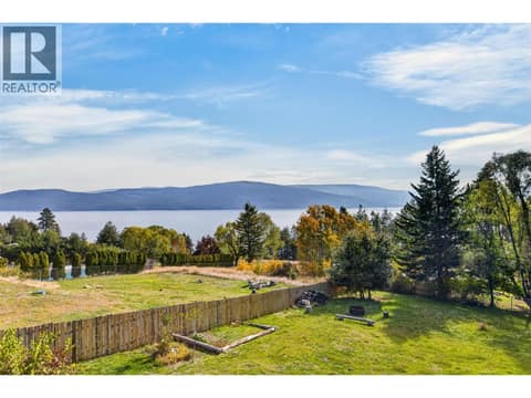 Beautiful lake and mountain views framed by mature trees and a spacious fully fenced yard. at 359 Kildare Way, Okanagan North, Vernon