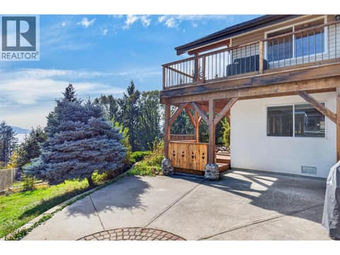 Large patio and wraparound deck create multiple outdoor living spaces surrounded by mature landscaping. at 359 Kildare Way, Okanagan North, Vernon