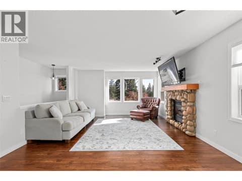Living Room | Main Level - with large windows & gas fireplace at 3220 McIver Road, Glenrosa, West Kelowna