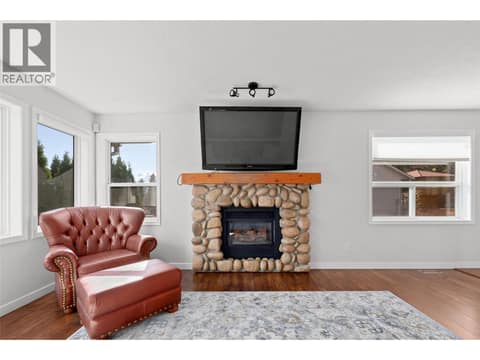 Living Room | Main Level - with large windows & gas fireplace at 3220 McIver Road, Glenrosa, West Kelowna