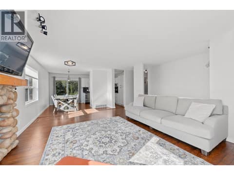 Living Room | Main Level - with large windows & gas fireplace at 3220 McIver Road, Glenrosa, West Kelowna