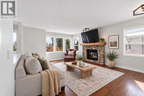 Spacious & bright main living space with gas fireplace! ** PARTIAL VIRTUAL STAGING & AI GENERATED ** at 3220 McIver Road, Glenrosa, West Kelowna