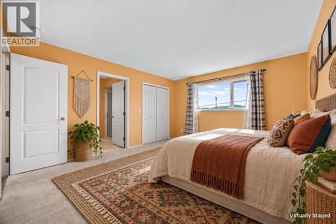 Primary bedroom with virtually staged furnishings at 884 Mission Springs Crescent, Lower Mission, Kelowna