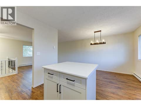 Kitchen and island overlooks dining room area at 246 Briarwood Road, Rutland North, Kelowna