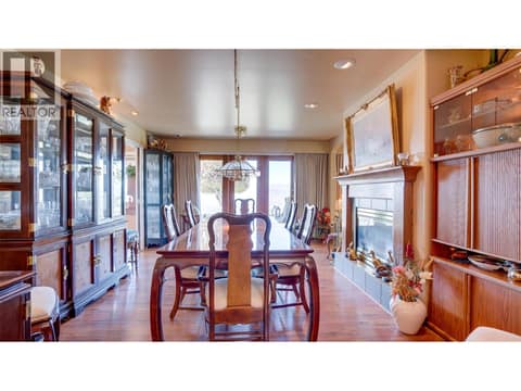 Impressive dining room has a patio door and gas fireplace. at 3200 Greenwood Road, South BX, Vernon