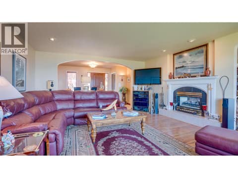 The gas fireplace is double-sided between the living room and dining room. at 3200 Greenwood Road, South BX, Vernon