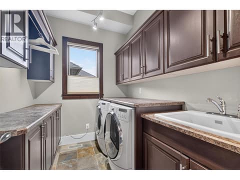 Complete laundry room on the main level at 734 Marin Crescent, Upper Mission, Kelowna
