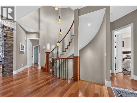 Curved statement staircase leads to the loft & lower level at 734 Marin Crescent, Upper Mission, Kelowna