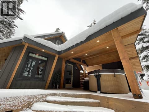 Covered deck and outdoor spa beside the cabin entrance at 1166 Apex Mountain Road, Penticton Apex