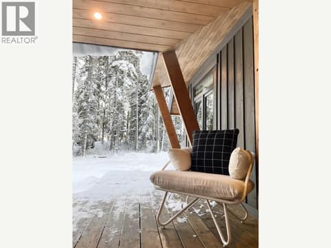 Covered deck seating overlooking the snowy yard at 1166 Apex Mountain Road, Penticton Apex