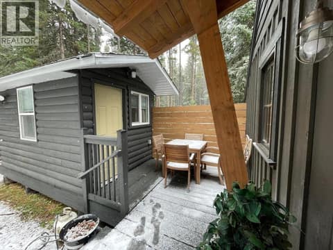 Deck area with detached outbuilding, seating, and fire bowl at 1166 Apex Mountain Road, Penticton Apex