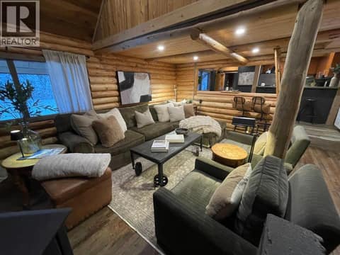 Log-walled living room with sectional seating and exposed timber post at 1166 Apex Mountain Road, Penticton Apex