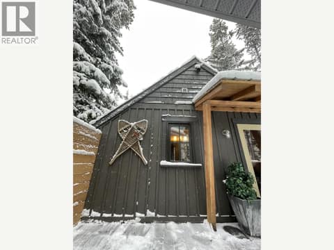 Side exterior with dark siding and mountain-home details at 1166 Apex Mountain Road, Penticton Apex