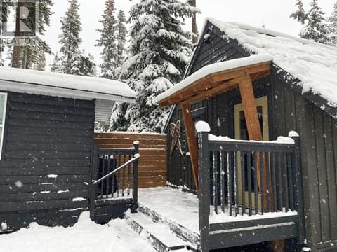Snowy exterior showing the cabin and detached outbuilding at 1166 Apex Mountain Road, Penticton Apex