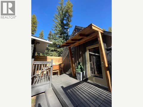 Summer view of the deck and covered entrance at 1166 Apex Mountain Road, Penticton Apex