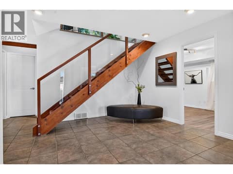 The lower level features a bright office or studio, fourth bedroom, third bathroom, laundry, and a spacious gym or flex room. at 183 Magic Drive, Glenmore, Kelowna