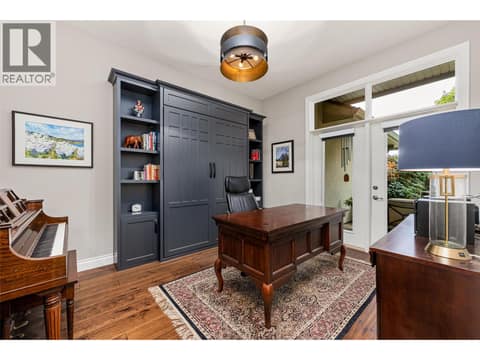 Den just off of the foyer with a built-in queen sz Murphy bed and access to the courtyard at 3887 Gallaghers Parkway, South East Kelowna