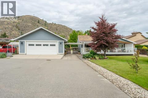 Front of home with large driveway at 860 Fairview Road, Oliver