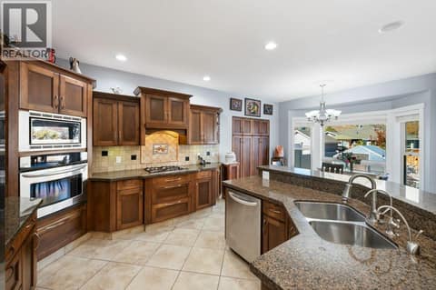 Granite counters, kitchen island, built-in oven, gas cooktop at 1124 Fairview Road, Oliver