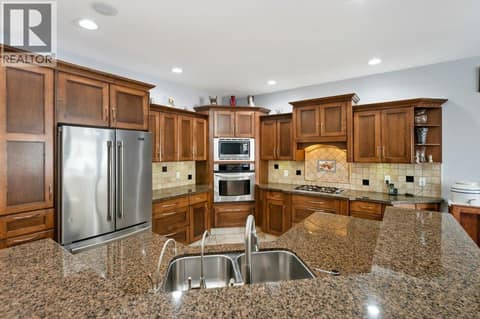 Kitchen - granite counters, built-in oven, gas cooktop at 1124 Fairview Road, Oliver